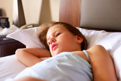 Portrait of cute girl lying on bed at home