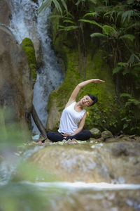 Woman exercising against waterfall
