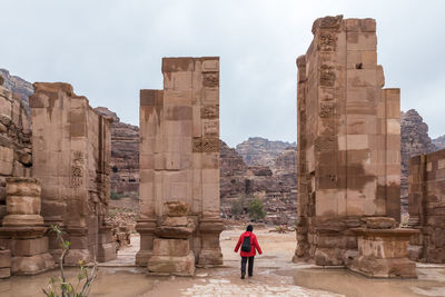 Rear view of woman standing at historical building