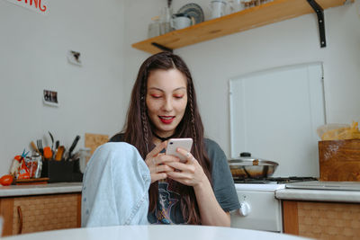 Young beautiful woman with the smartphone at home