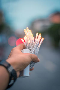 Cropped hand holding illuminated string light