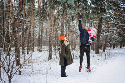 Outdoor family activities for happy winter holidays. happy father and mother playing with little