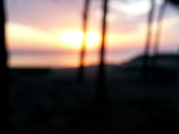 Defocused image of sea against sky at sunset