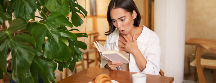 Young woman using mobile phone while sitting at home