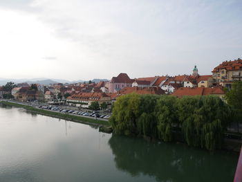 Panoramic shot of townscape by river against sky