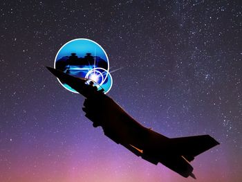 Low angle view of illuminated light against sky at night