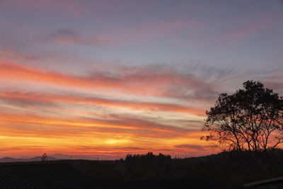 Scenic view of silhouette trees against romantic sky at sunset