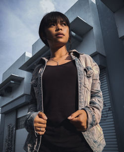 Portrait of young man standing against built structure