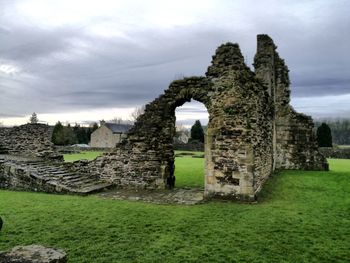 Old ruins on field against sky