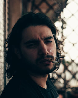 Portrait of young man smoking cigarette