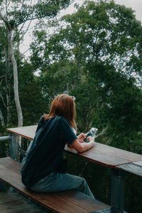 Rear view of woman sitting on bench