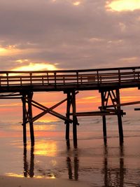 Pier on sea at sunset