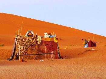 View of people on desert against clear sky