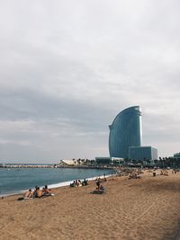 People at beach against sky