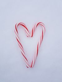 Heart shape candy canes on white background