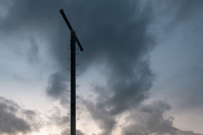 Low angle view of silhouette pole against sky