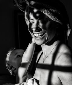 Close-up of smiling mother holding cute baby son