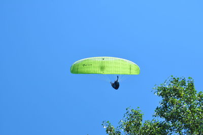 Low angle view of paragliding against clear sky