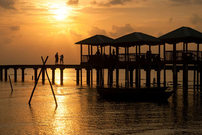 Pier on sea at sunset