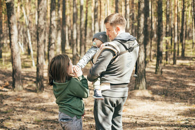 Rear view of father and son in forest