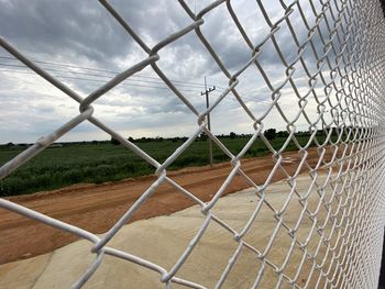 Scenic view of field seen through chainlink fence
