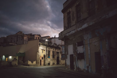 Street amidst buildings against sky at night