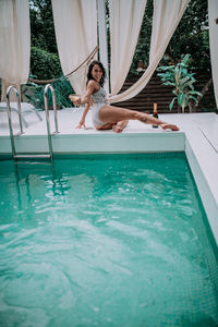 Woman sitting in swimming pool