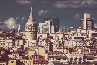 Buildings in city against cloudy sky