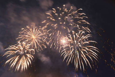 Bright fiery fireworks against the dark night sky in the smoke. horizontal photo