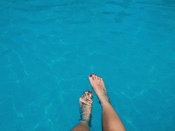 Low section of woman in swimming pool on sunny day