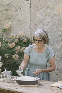 Woman holding ice cream in bowl on table
