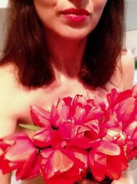 Close-up of woman holding pink flower