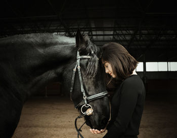 Man with horse in stable