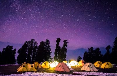 Scenic view of himalayan mountains with illuminated tends  against stars in the sky at night