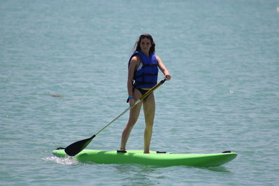 Rear view of woman with umbrella on sea