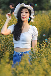 Beautiful young woman wearing hat on field