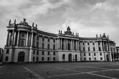 Facade of historic building against cloudy sky