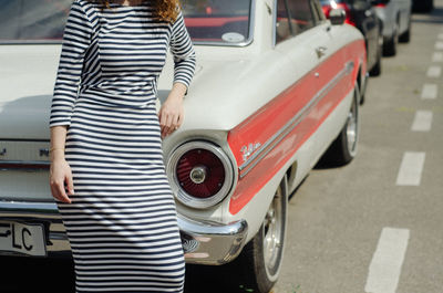Rear view of woman standing on street in city