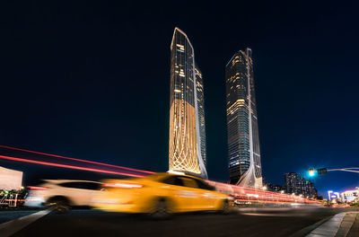 Light car on road against sky at night