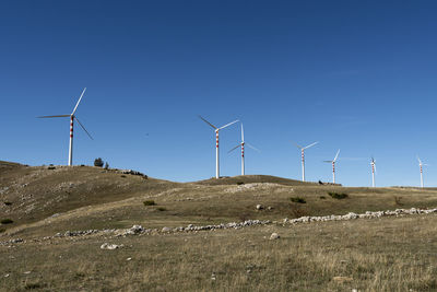 Windmill on field against clear sky