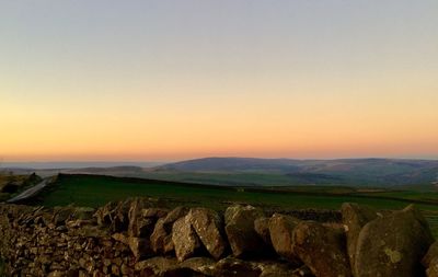 Scenic view of field against clear sky during sunset