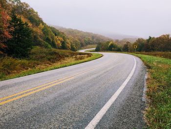 Empty road along countryside landscape