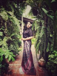 Portrait of woman standing by tree