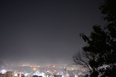 Illuminated city against sky at night