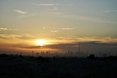 Scenic view of silhouette buildings against sky during sunset