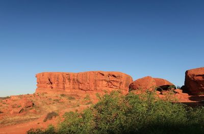 Rock formations on landscape against blue sky