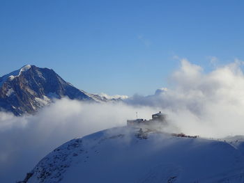 Scenic view of snowcapped mountains against blue sky