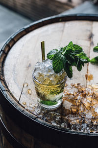 Making a mint julep cocktail with bourbon, fresh mint, crushed ice on whiskey barrel