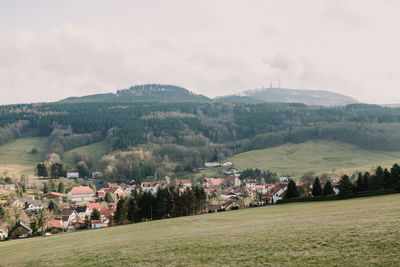 Scenic view of field by buildings against sky