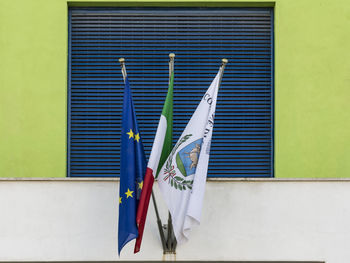 Multi colored flags against blue wall